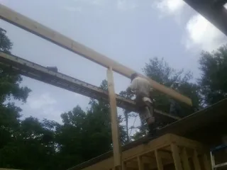 Carpenter setting a ridge beam over a new addition frame — Ice Dam Removal by Roofing Brothers in Bonne Terre