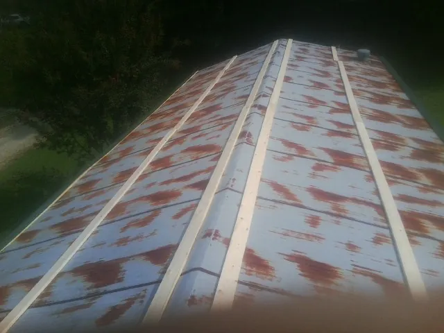 Rusted metal roof panels with new wood purlins before replacement — Storm Damage Roof Repair in Bonne Terre by Roofing Brothers